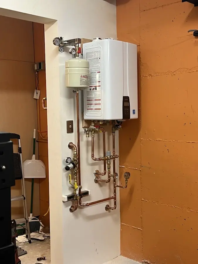 Plumbing technician inspecting water heater connections in Roseburg